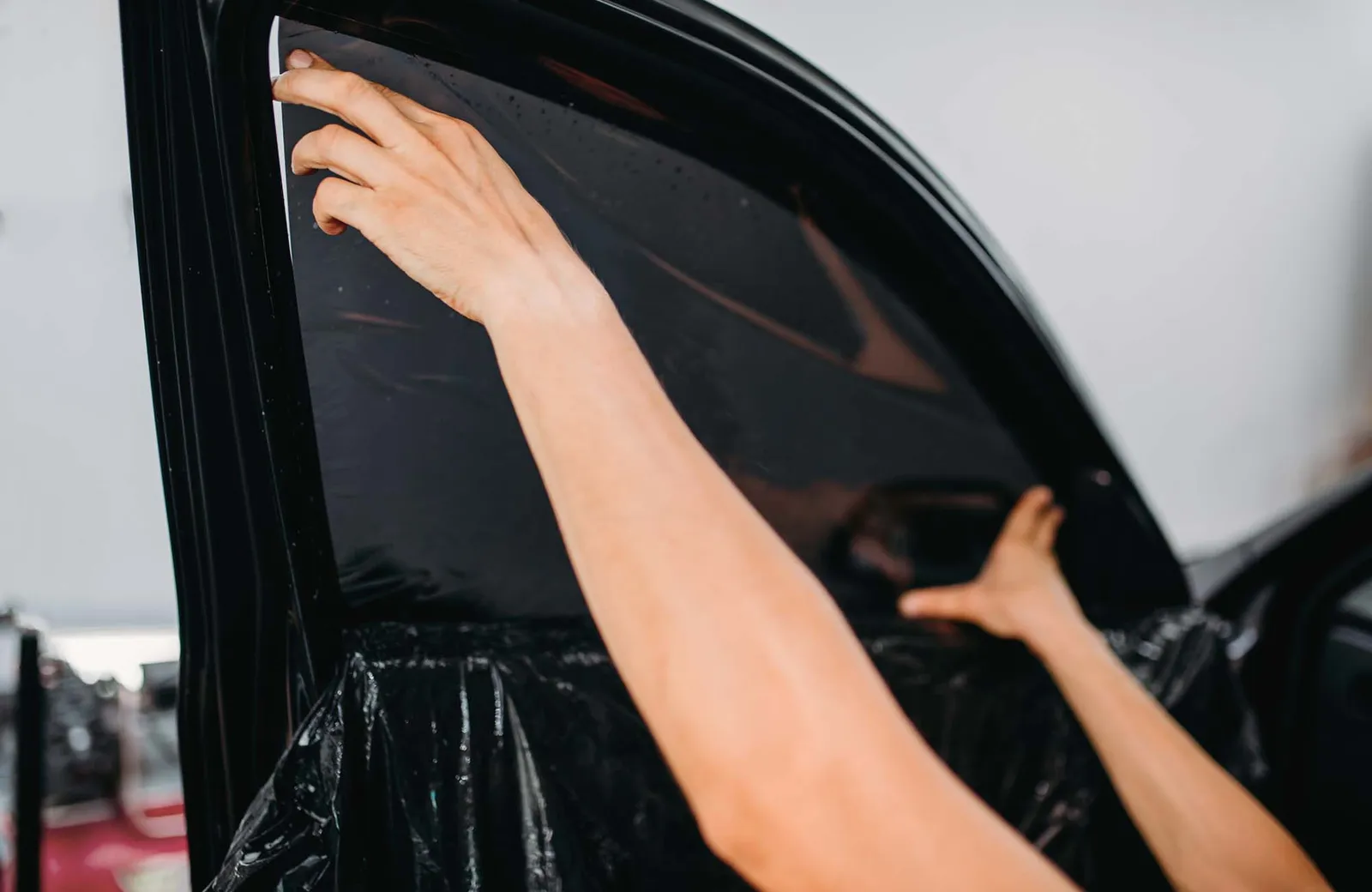 Specialist work, car tinting film installation. Male specialist work with window, car tinting film installation process, installing procedure